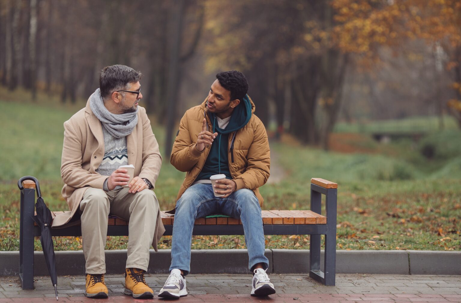 Two men sitting together on a park bench